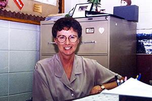 Dr. Marilyn Graves setting at desk in physical education department.